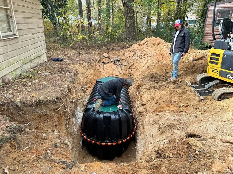 Excavated septic tank and distribution work during a septic replacement