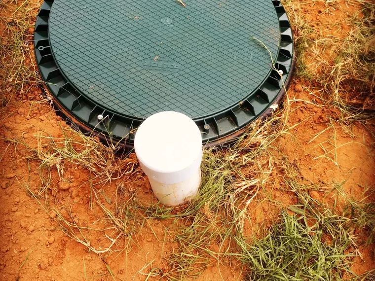 Green septic tank lid and riser set flush after a repair